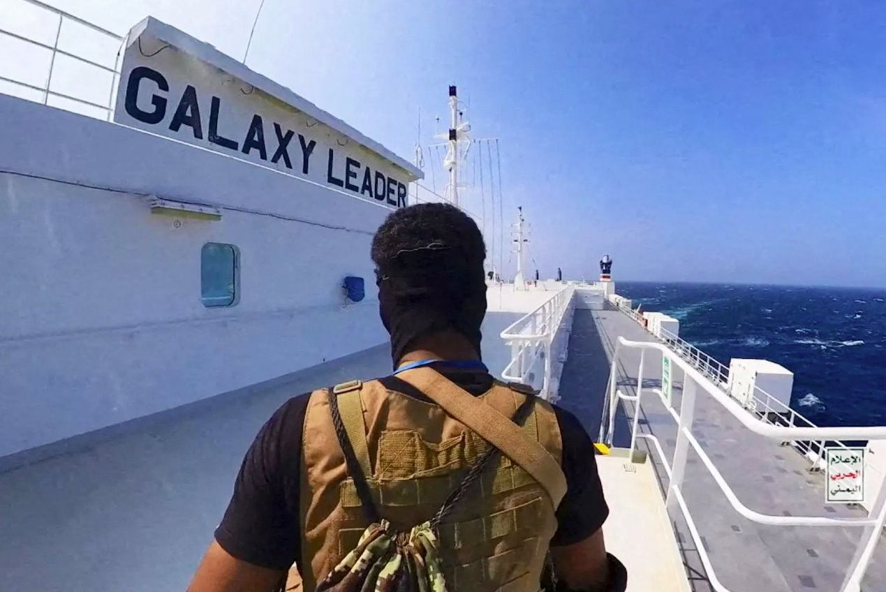 2023年11月20日發(fā)布的這張照片中，一名胡塞戰(zhàn)士站在紅海的銀河領(lǐng)袖號(hào)貨船上。