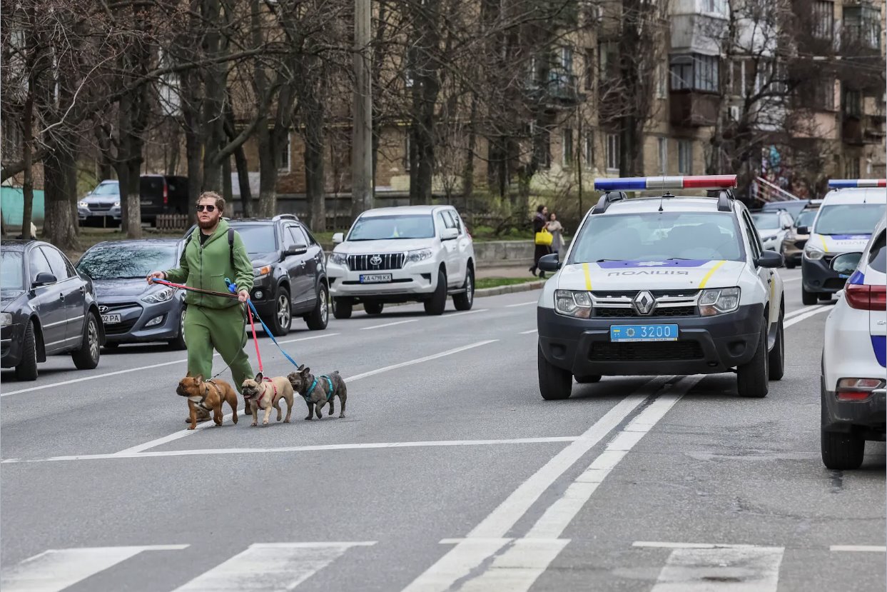 2024年3月25日，烏克蘭基輔，在俄羅斯襲擊烏克蘭期間，一名當?shù)鼐用駧е墓吩诙砹_斯導彈襲擊地點附近散步。