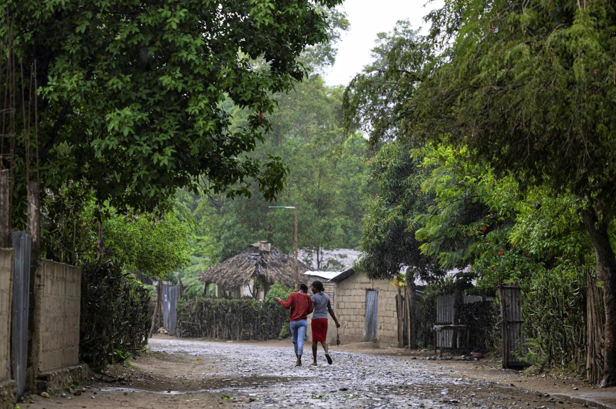 2024年4月27日，海地自由堡馬爾費(fèi)蒂社區(qū)，婦女在雨中行走。