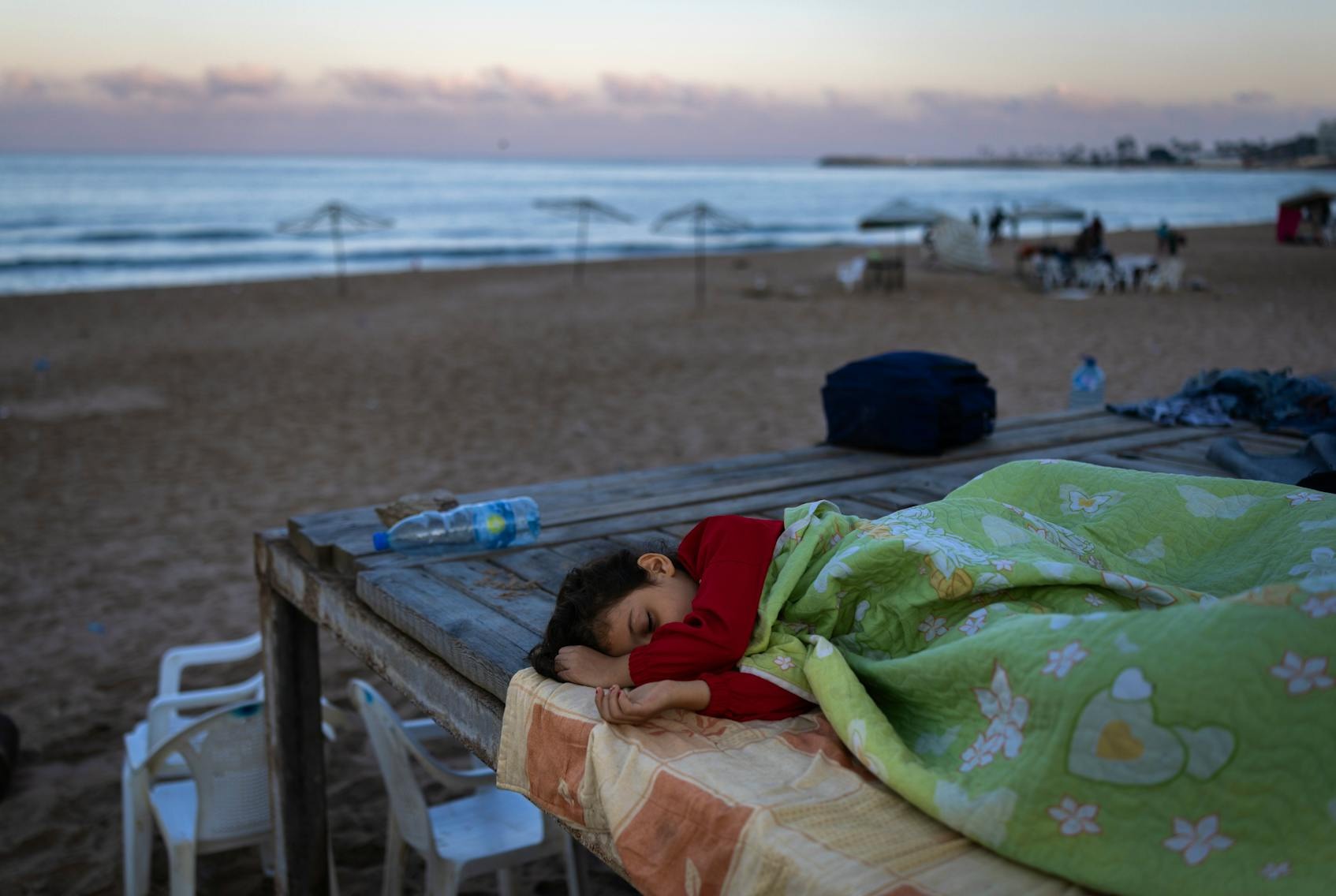 2024年9月29日，黎巴嫩貝魯特，一名男孩和家人逃離空襲，在貝魯特的RamletAlBaida海灘避難。