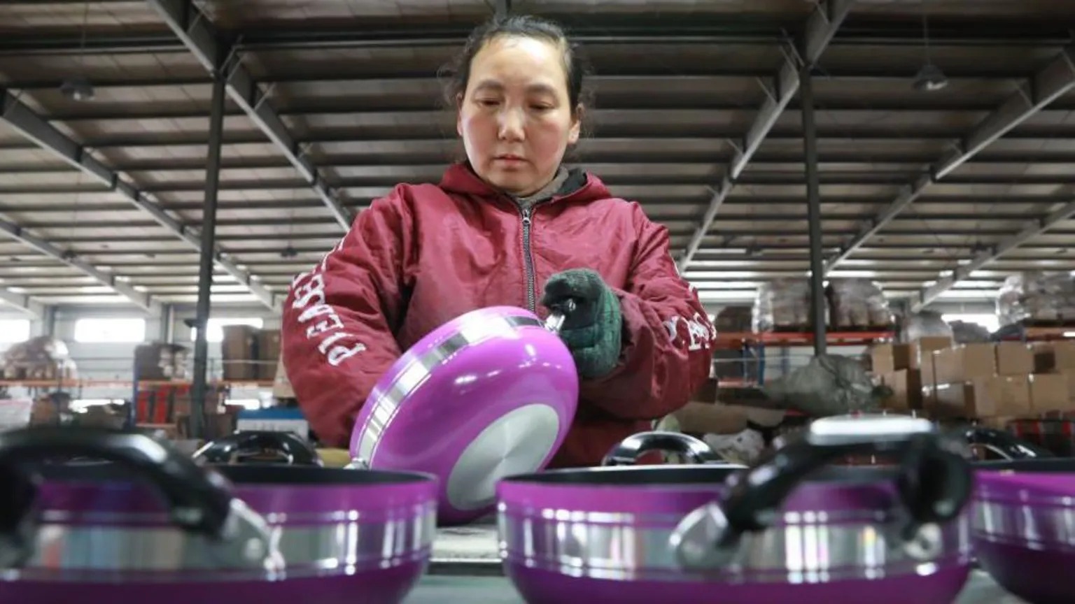 浙江省杭州市，一名婦女在一家生產(chǎn)鋁制煎鍋的工廠工作，煎鍋用于出口。